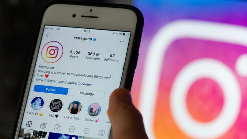 Arka planda Instagram logosu ve önde telefonda açık Instagram uygulaması